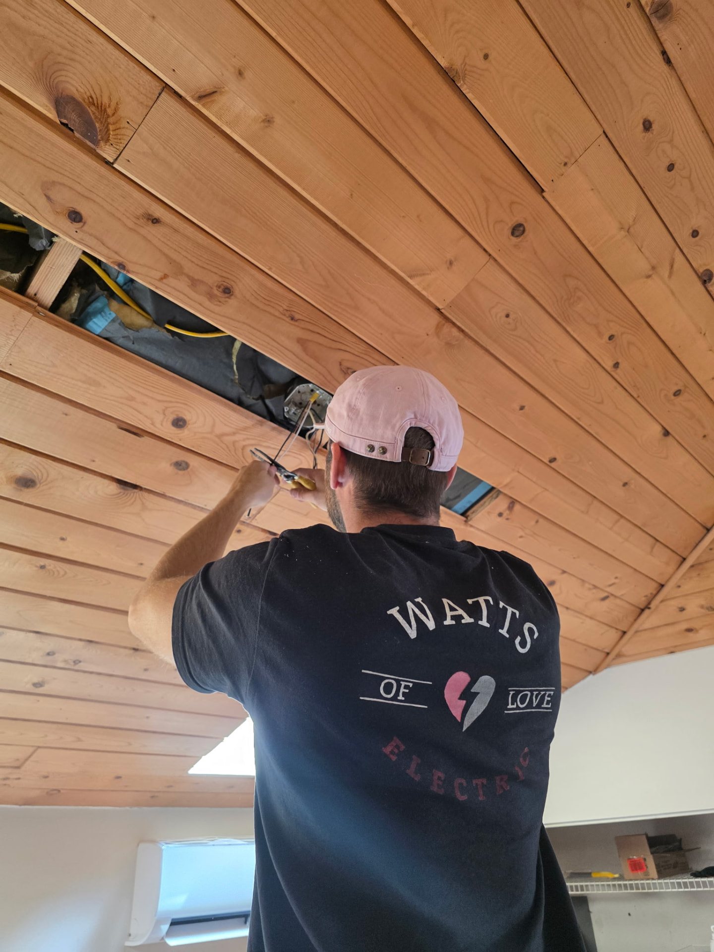 Watts of Love Electric technician wiring a wood ceiling